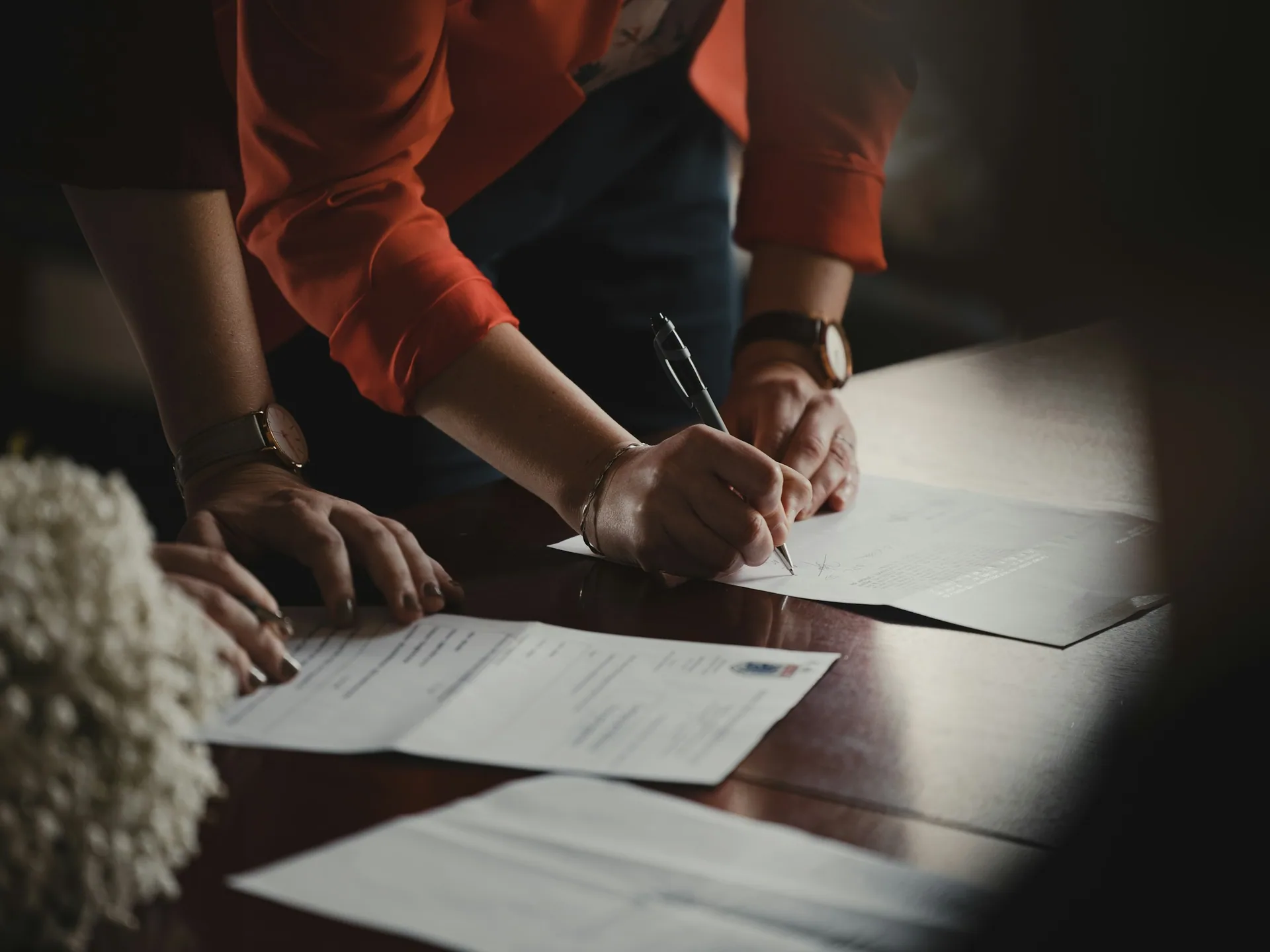 Hands review and sign documents on a table